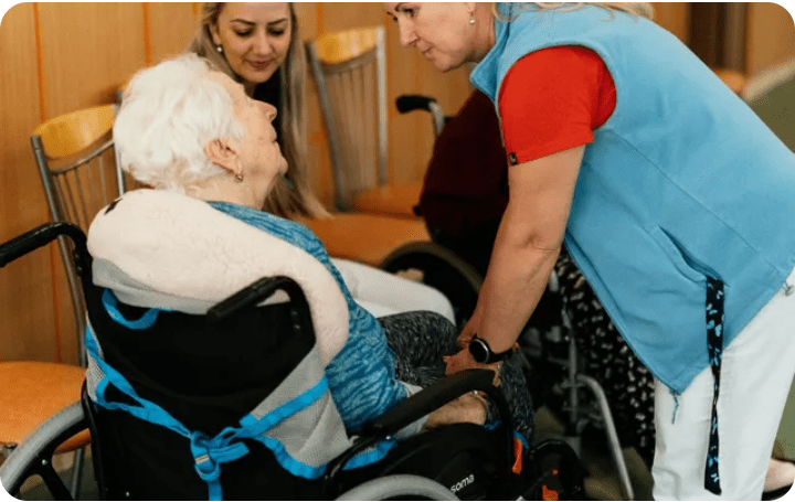 Elderly woman in wheelchair with caregivers
