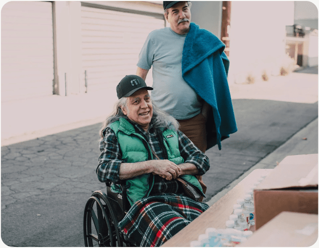 Elderly woman in wheelchair smiling outdoors