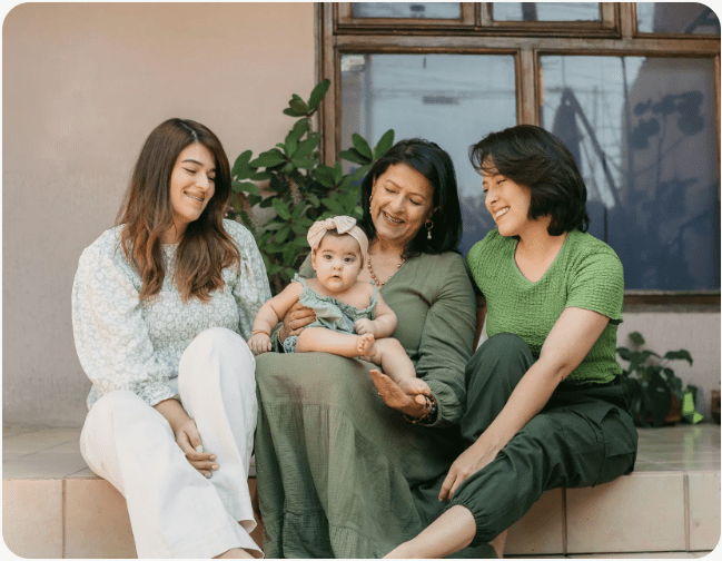 Three women sitting with a baby
