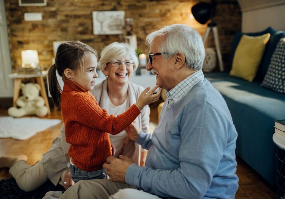 Grandparents playing with granddaughter at home