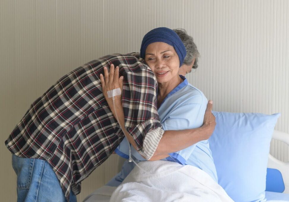 Patient hugging visitor in hospital room