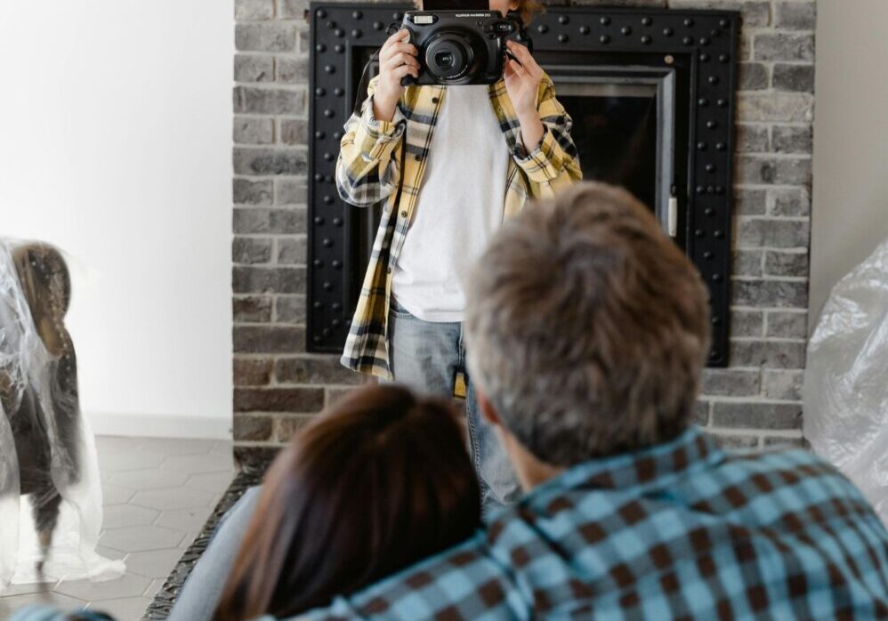 Young photographer capturing family moment indoors